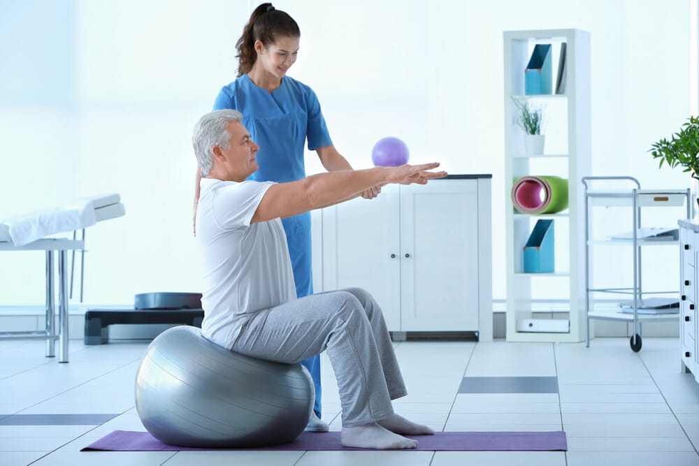 physiotherapist working with an elderly patient