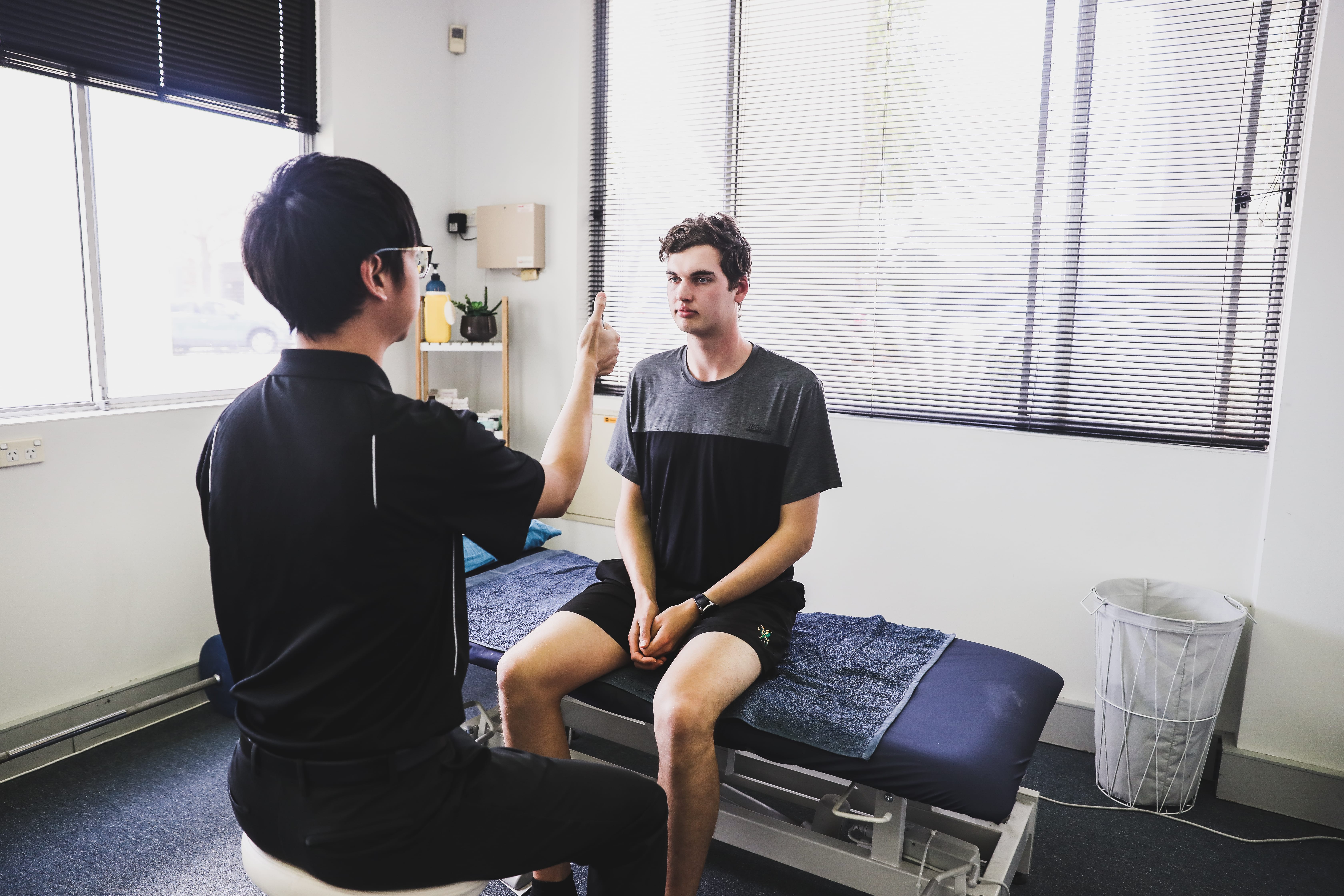 Physiotherapist assessing patient with dizziness using eye movement test during vestibular physiotherapy for positional vertigo
