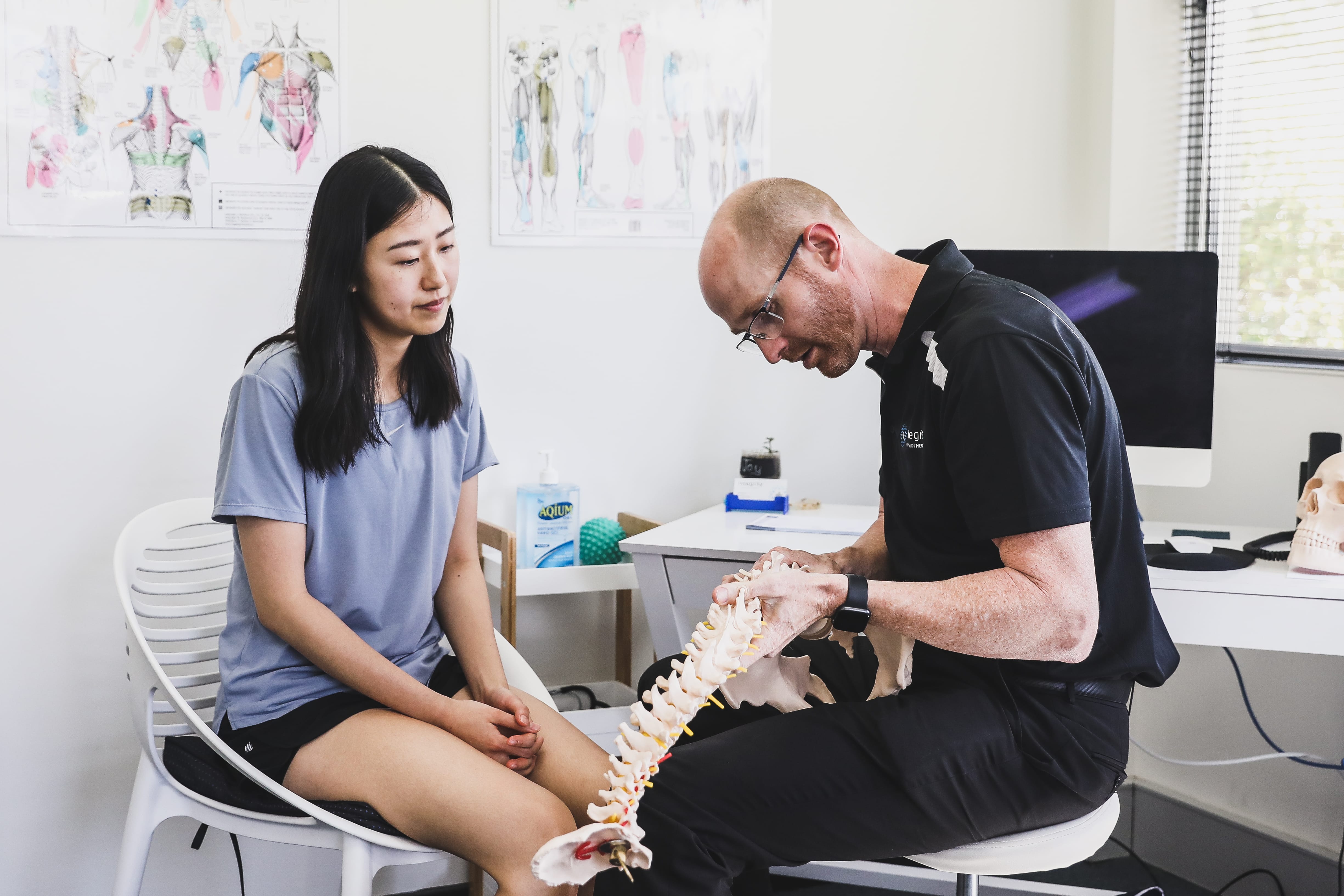 Physiotherapist Leslie Trigg explaining a spinal condition to a patient during a consultation at Integrity Physiotherapy Como, South Perth
